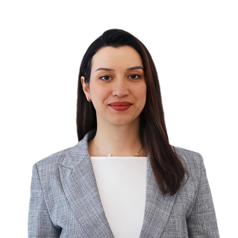 Professional headshot of a smiling woman with dark hair wearing a gray blazer against a white background.